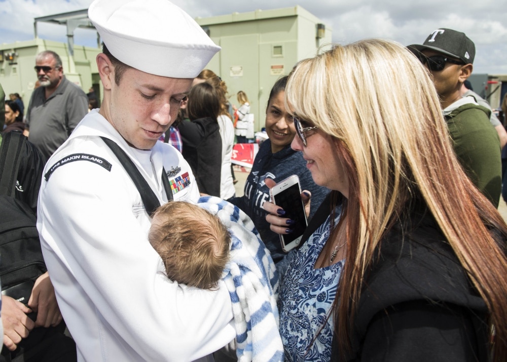 Hospitalman Allan Henson meets his newborn son upon the return of amphibious assault ship USS Makin Island (LHD 8) to Naval Base San Diego from deployment. 